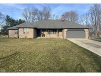 Charming brick ranch home featuring an attached two car garage and a well-manicured front lawn at 7020 Bloomfield Dr, Indianapolis, IN 46259