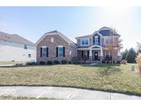Charming two-story brick home with landscaped front yard and inviting curb appeal at 7055 Scarborough Ct, Columbus, IN 47201