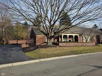Charming brick home with a manicured lawn and mature trees adding curb appeal at 7943 Beaumont Green East Dr, Indianapolis, IN 46250