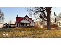 Charming farmhouse featuring a red roof, brick foundation, and a welcoming front porch at 8089 W Old State Road 67, Paragon, IN 46166