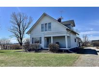 Charming two-story home with covered porch and mature landscaping sits under a clear blue sky at 810 S 400 W, Bargersville, IN 46106
