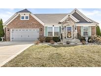 Charming brick and stone home with a two-car garage, manicured lawn, and inviting front entrance at 8759 Buttonbush Cir, Plainfield, IN 46168