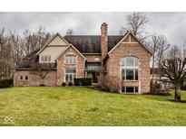 Charming brick home featuring a manicured lawn and mature trees, creating a welcoming curb appeal at 11691 Diamond Pointe Ct, Indianapolis, IN 46236
