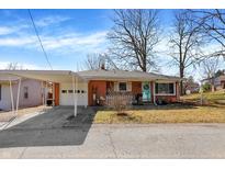 Charming brick home features a covered carport, landscaped front yard, and a bright blue front door at 230 N School St, Fortville, IN 46040