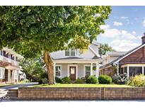 Charming home featuring mature trees, a welcoming front porch, and manicured landscaping at 4707 N Park Ave, Indianapolis, IN 46205