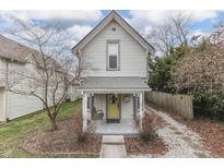 Charming two-story home featuring a quaint front porch with a swing and a yellow front door at 475 E Madison St, Franklin, IN 46131