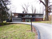 Inviting two-story home with a brick facade, covered balcony, attached garage, and curved driveway at 490 Valley Dr, Martinsville, IN 46151