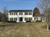 Charming two-story home with classic curb appeal, painted white with black shutters on a sunny day at 5420 N Arlington Ave, Indianapolis, IN 46226