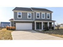 Charming two-story home featuring a two-car garage, covered porch, and a combination of brick and siding at 6216 N Woods Edge Ct, McCordsville, IN 46055