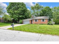 Charming brick home with a well-manicured lawn and mature trees at 629 Williamsburg Ln, Greenwood, IN 46142