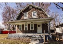 Charming brown two-story home with a cozy front porch and well-maintained yard at 706 N Euclid Ave, Indianapolis, IN 46201
