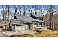 Charming two-story home with stone accents, a two-car garage, and a deck overlooking a tree-filled yard at 7899 S Timber Cliff Ln, Trafalgar, IN 46181
