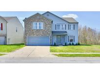 Charming two-story home with a brick facade, attached garage, and well-maintained landscaping at 8630 Aylesworth Dr, Camby, IN 46113