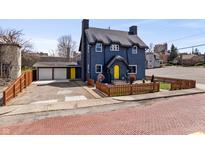 Inviting blue two-story home with yellow door and brick street at 914 Chase St, Anderson, IN 46016