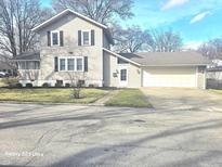Charming two-story home with a well-manicured lawn and attached two-car garage at 1302 Indiana Ave, Anderson, IN 46012