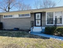 Charming home featuring gray brick, updated windows, and a secure front entrance at 1607 Elmhurst Dr, Indianapolis, IN 46219