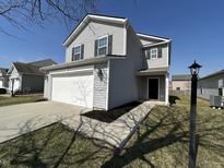 Charming two-story home with attached garage, black shutters and manicured landscaping at 2402 Middle View Dr, Columbus, IN 47201
