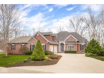 Charming two-story home features a brick and wood facade, landscaped yard, and a long, paved driveway at 4965 N 500 W, Columbus, IN 47201
