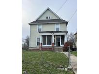 Charming two-story home with a front porch, offering a glimpse of a cozy living space at 550 Sutherland Ave, Indianapolis, IN 46205