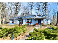 Charming single-story home with a blue exterior, complemented by a well-maintained yard and inviting walkway at 6120 E 106Th St, Fishers, IN 46038