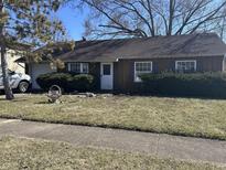 Cozy single-story home featuring a front yard with mature landscaping and attached one car garage at 654 Holiday Dr, Fortville, IN 46040
