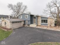 Striking home with a stone facade, complemented by a driveway and a detached garage, showcasing curb appeal at 6636 Albion Dr, Indianapolis, IN 46256