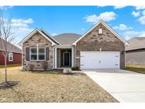 Charming single-Gathering home with brick exterior, a two-car garage, and a well-maintained front yard at 7326 Wooden Grange Dr, Indianapolis, IN 46259