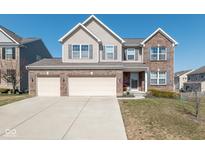 Charming two-story home with brick and vinyl siding and a three-car garage and concrete driveway at 11866 Bellhaven Dr, Fishers, IN 46038