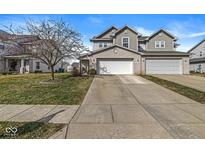 Charming home with a two-car garage and a well-maintained lawn, under a blue sky at 218 Clear Branch Dr, Brownsburg, IN 46112