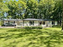 Charming brick home features a lush lawn, flowerbeds, and a convenient attached garage at 2408 E Stafford Pl, Martinsville, IN 46151