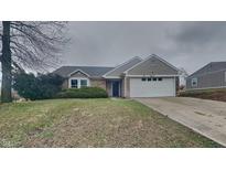 Charming one-story home featuring a well-maintained lawn, attached two-car garage, and welcoming entrance at 2617 N Temple Ave, Indianapolis, IN 46218