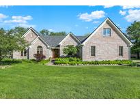 Charming brick home with a well-manicured lawn and lush landscaping creates inviting curb appeal at 37 Trotters Run, Brownsburg, IN 46112
