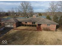 Brick home with a side entry garage and a large yard overlooking a lake at 3752 W North Wood Lake Dr, Columbus, IN 47201