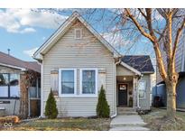 Charming home featuring mature trees, neutral siding, updated windows and front entrance with walkway at 546 E Merrill St, Indianapolis, IN 46203