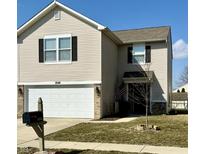 Charming two-story home featuring a large two-car garage and well-maintained lawn, with an American flag adding character at 8048 Grove Berry Dr, Indianapolis, IN 46239
