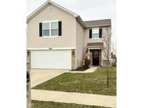 Charming two-story home with a well-kept lawn, attached two-car garage, and inviting entrance with an American flag at 8048 Grove Berry Dr, Indianapolis, IN 46239