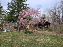 Charming home featuring lush landscaping and a blooming magnolia tree enhancing its curb appeal at 10960 Marlin Rd, Indianapolis, IN 46239