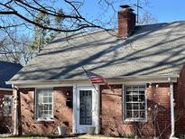 Charming brick home featuring a classic design, a well-maintained roof, and an American flag at 1230 Kessler Blvd E Dr, Indianapolis, IN 46220