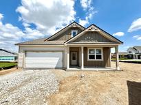 Charming single-story home featuring a garage and a welcoming front porch, set against a blue sky with scattered clouds at 1419 School Bell Dr, Greenwood, IN 46143