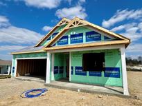 New construction home showcasing the framing, roof trusses and Kingspan GreenGuard weather resistant barrier at 1419 School Bell Dr, Greenwood, IN 46143