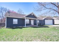 Charming one-story home features a well-manicured lawn and an attached garage at 1755 Pinion Ct, Columbus, IN 47201