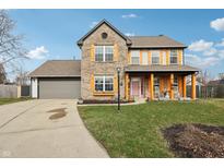 Charming two-story brick home with shutters, inviting porch, and attached two-car garage at 17739 Willow Creek Way, Westfield, IN 46074