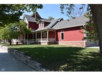 Charming red home featuring a welcoming front porch and well-maintained lawn at 189 S Jefferson St, Martinsville, IN 46151