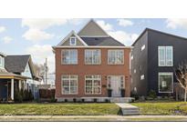 Charming two-story brick home featuring symmetrical windows and a well-maintained front yard at 2031 Central Ave, Indianapolis, IN 46202