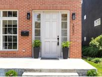 Charming brick home featuring a front door with sidelights and decorative plants at 2031 Central Ave, Indianapolis, IN 46202