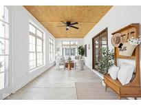 Bright sunroom with large windows, comfortable seating, and a decorative ceiling fan at 2031 Central Ave, Indianapolis, IN 46202