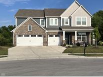 Charming two-story home boasts a brick and siding exterior, three-car garage and a welcoming front porch at 3535 Merchmont Rd, Bargersville, IN 46106