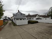 Street view of a charming home with a white picket fence and a spacious driveway at 367 W Broadway St, Shelbyville, IN 46176