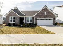 Charming brick home featuring a two-car garage, manicured lawn, and inviting curb appeal at 3865 Kensington Dr, Danville, IN 46122