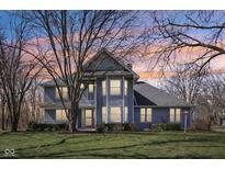 Charming two-story home with a landscaped front yard and a mix of mature trees, captured at sunset at 405 Bays Dr, Noblesville, IN 46062